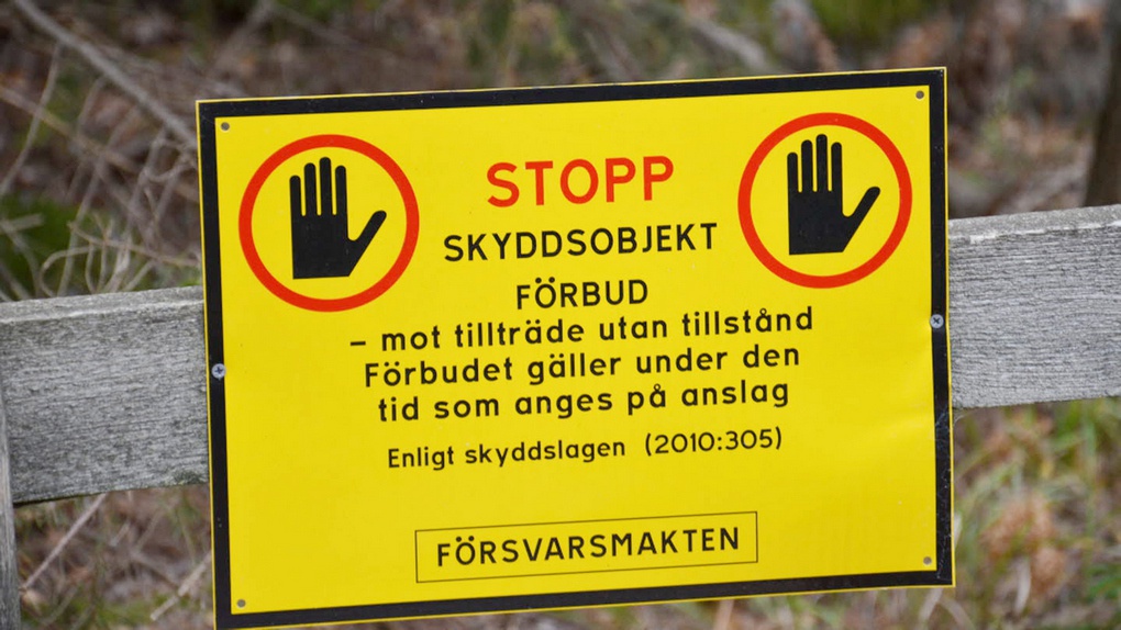 Вывеска на шведском языке «Охраняемый объект: Стоп! Охраняемый объект. Въезд без разрешения запрещён на срок, указанный в уведомлении. В соответствии с законом об охране (2010:305)».