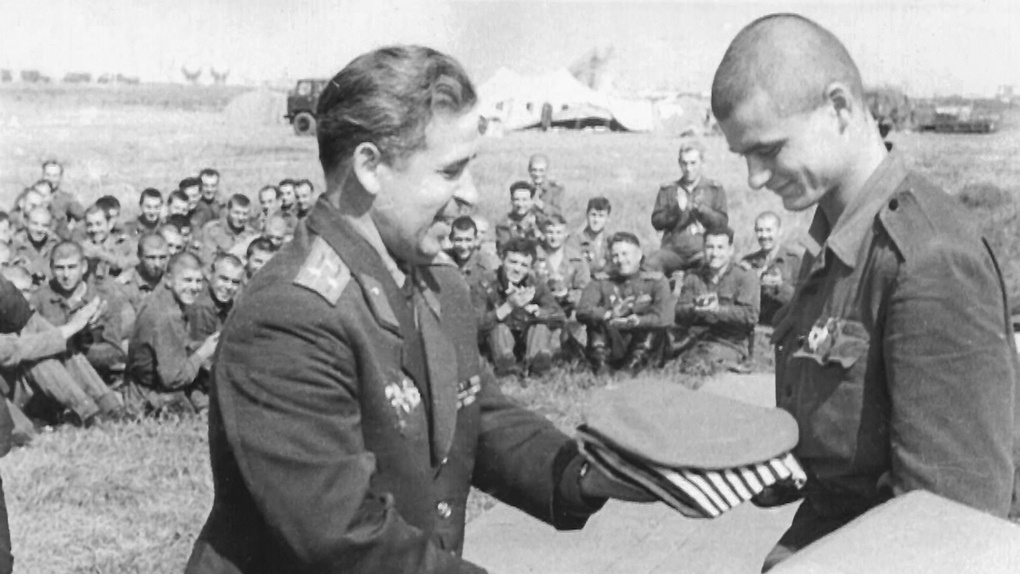 Начальник штаба 7-й гвардейской воздушно-десантной дивизии полковник А.С. Коршун вручает малиновый берет и тельняшку десантнику. Прага, аэродром «Рузина», сентябрь 1968 г.
