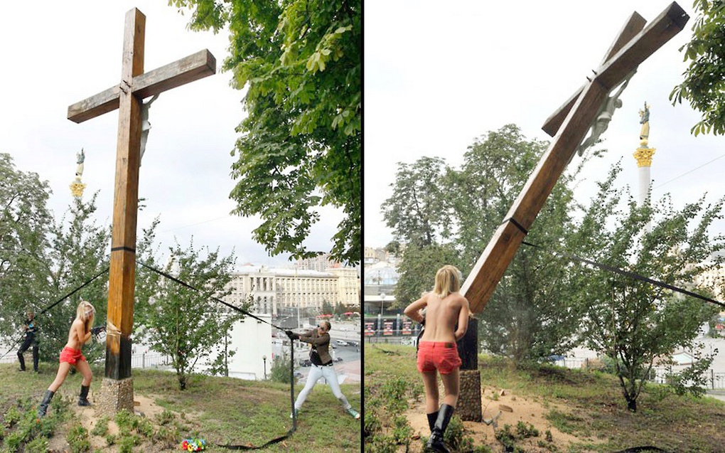 Эксгибиционистки из «Фемен» спиливают крест на Поклонной горе в Киеве.