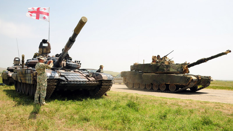 Грузинские танкисты с интересом разглядывают американский танк.