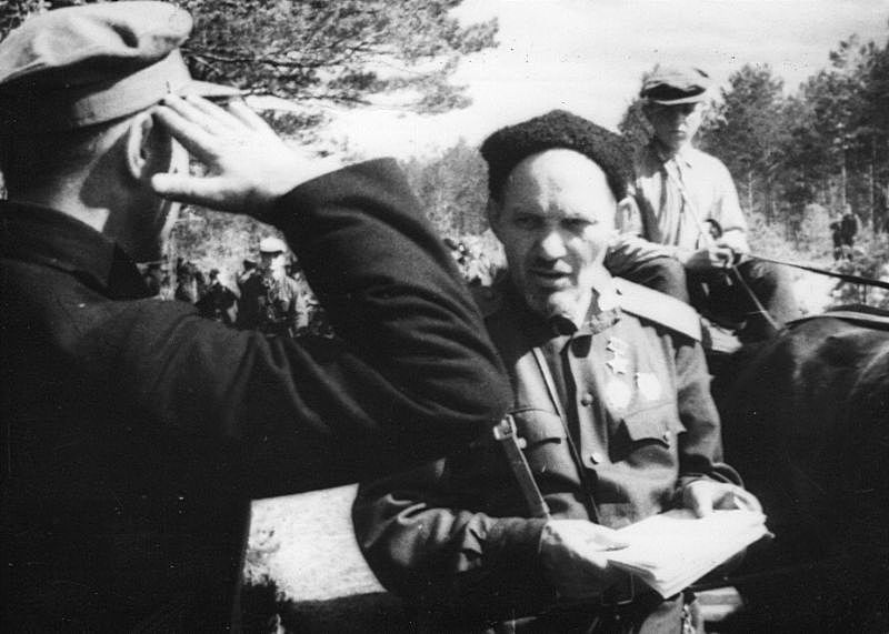 Герой Советского Союза генерал-майор С.А. Ковпак принимает рапорт партизана.