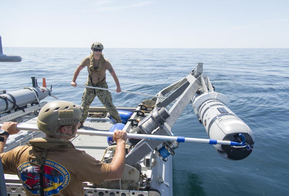Моряки ВМС США опускают REMUS 600 в воду во время учений по противоминной защите.