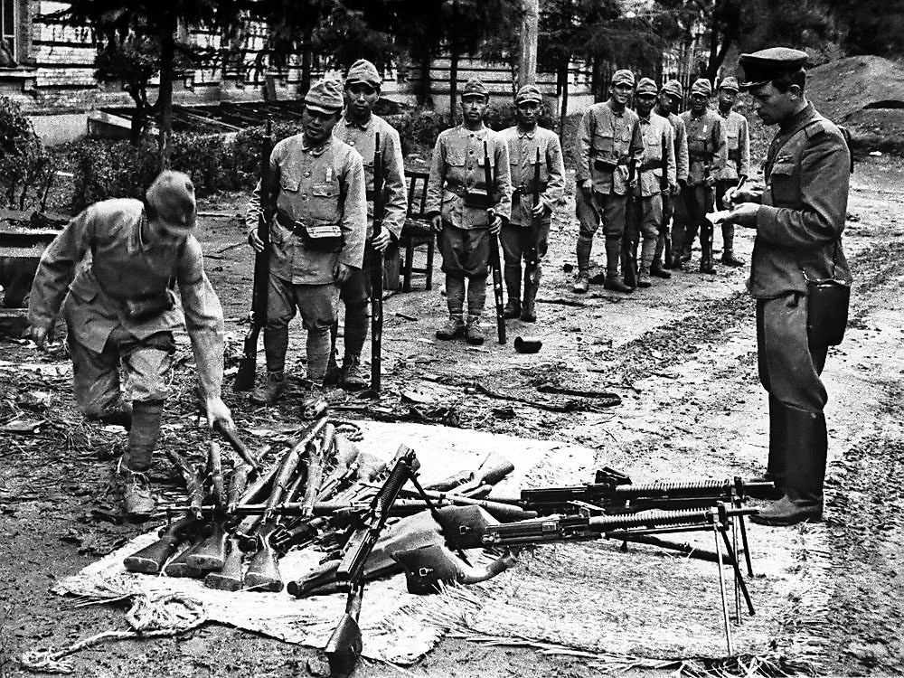 Солдаты японской армии сдают оружие.