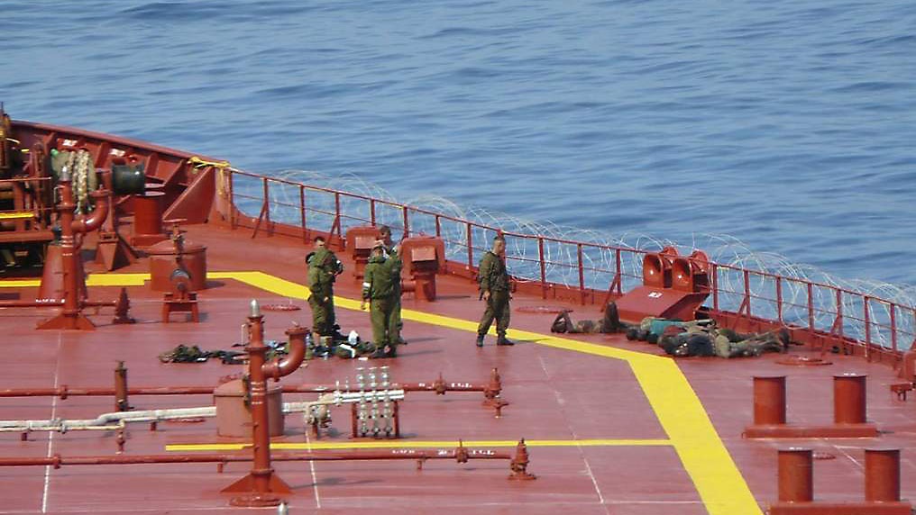 Обезоруженные пираты под охраной морских пехотинцев на палубе танкера «Московский университет».