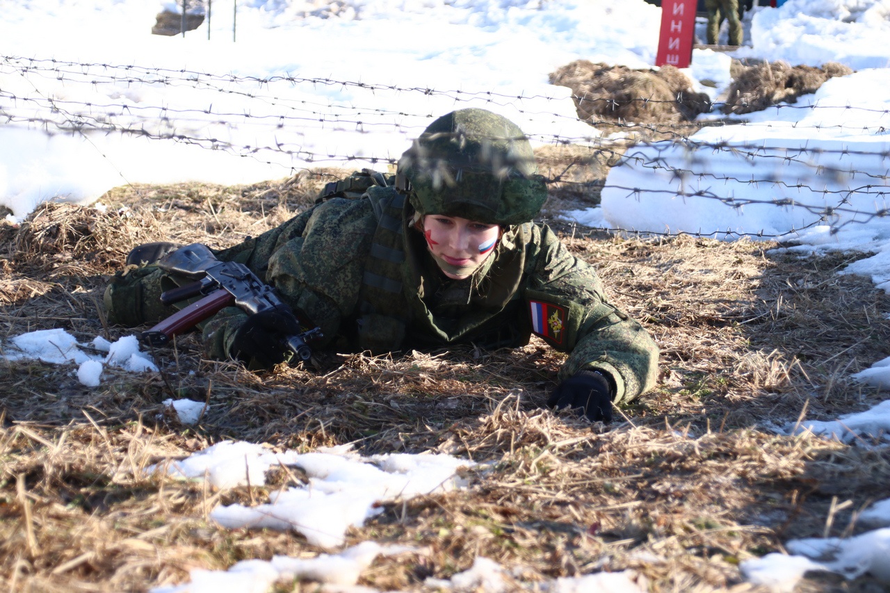 Ефрейтор Юлия Тимохова падает в грязь и ужом проползает под колючей проволокой.
