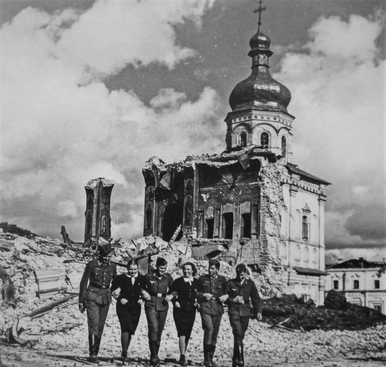 Немецкие солдаты и девушки из женской организации НСДАП на прогулке у разрушенного Успенского собора Киево-Печерской лавры.