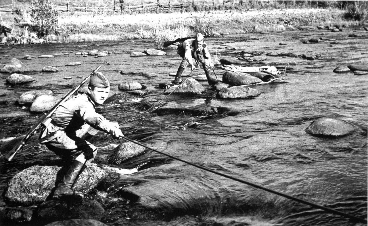 Советские связисты прокладывают линию связи через реку.