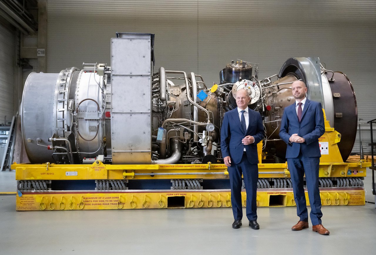 Канцлер Германии Олаф Шольц вместе с Кристианом Брухом, генеральным директором Siemens Energy, у турбины, полученной из Канады.