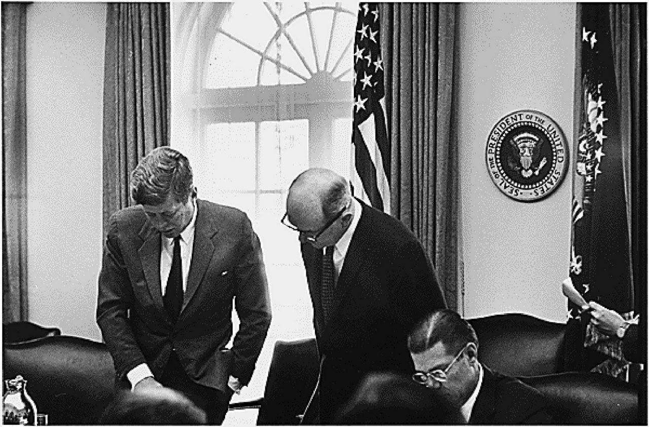 Президент США Джон Ф. Кеннеди, госсекретарь США Дин Раск, министр обороны Роберт С. Макнамара (слева направо) обсуждают сложившуюся ситуацию 29 октября 1962 года.