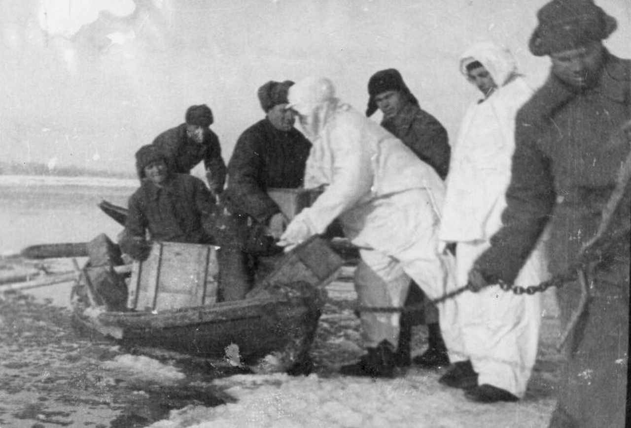 Бойцы РККА выгружают из лодки боеприпасы на берег Волги.