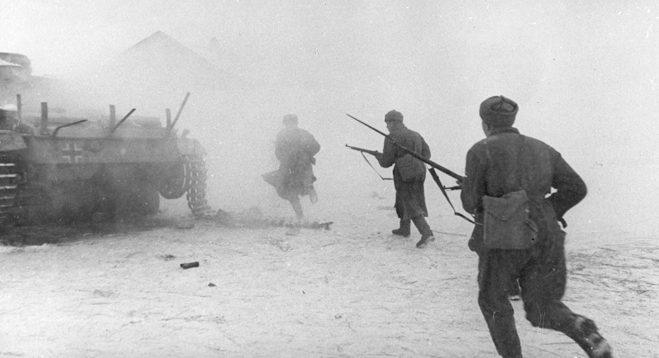 Красноармейцы бегут мимо подбитого немецкого танка Pz.Kpfw. III в атаке под Сталинградом.