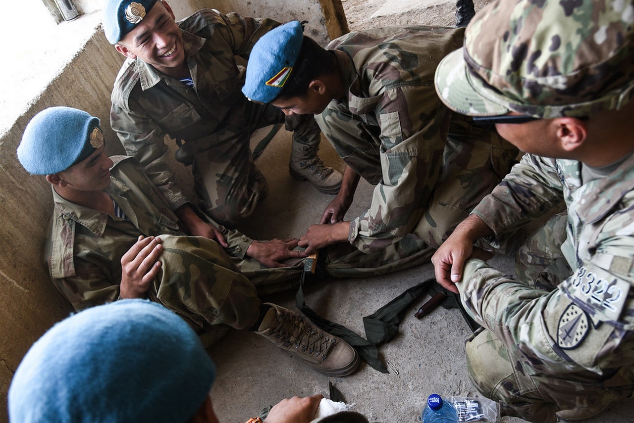 На учениях «Региональное сотрудничество-2022» американский инструктор обучает таджикских солдат оказанию первой помощи.