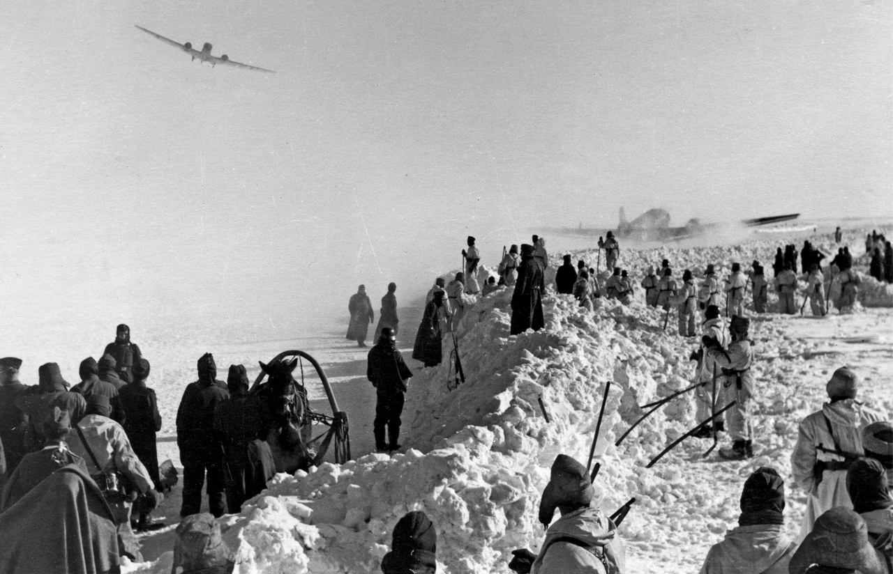 Немецкий транспортный самолёт Юнкерс Ю-52 заходит на посадку на аэродром под Сталинградом. Другой Ю-52 готовится взлетать. Декабрь 1942 г.