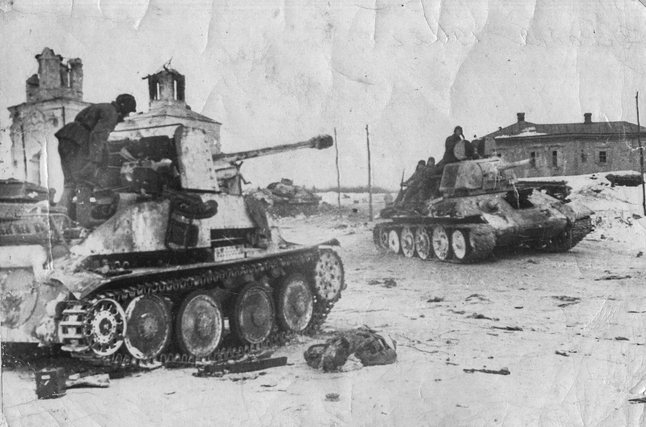 Советский танк Т-34 проезжает мимо брошенной немецкой САУ Marder III в освобождённом селе Дубовиково. 17 декабря 1942 г.
