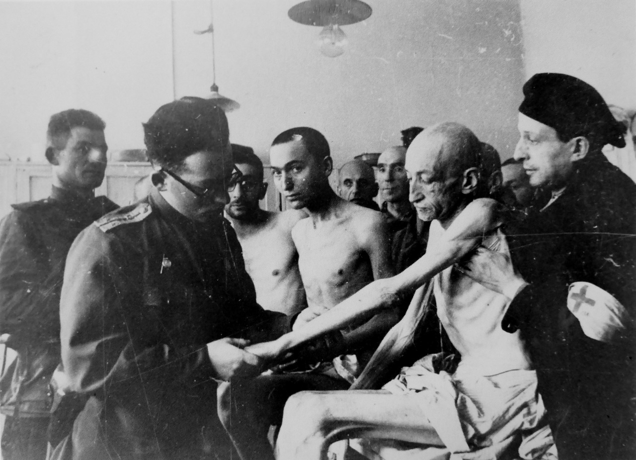 Советский офицер медицинской службы осматривает освобождённых узников концлагеря Освенцим.