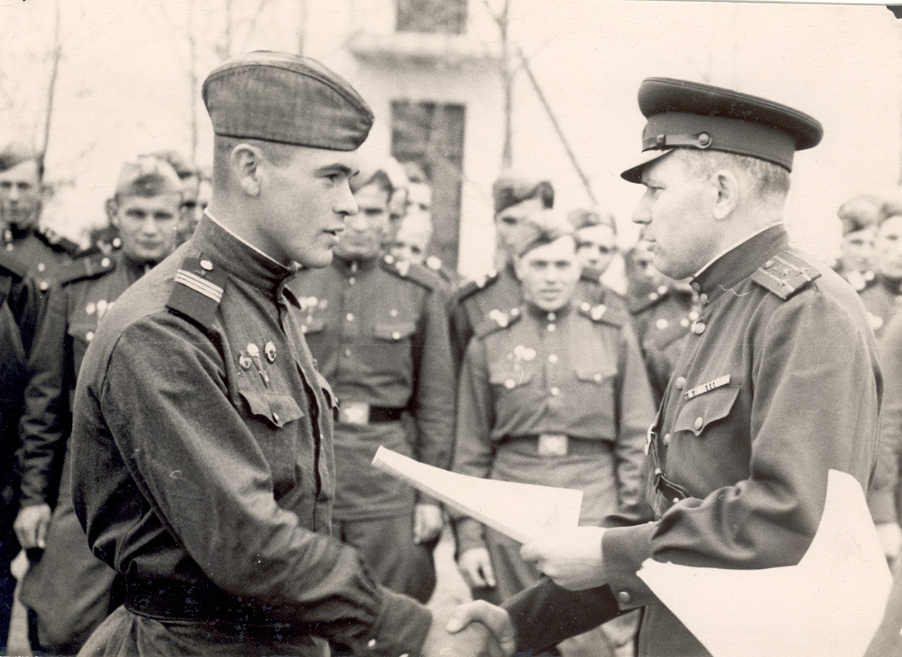Командир десантного полка полковник А. Лазаренко (справа) вручает грамоту отличившемуся воину.