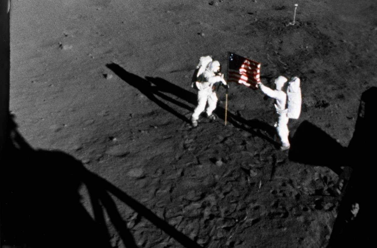 Нил Армстронг (слева) и Эдвин Олдрин устанавливают на Луне флаг США.
