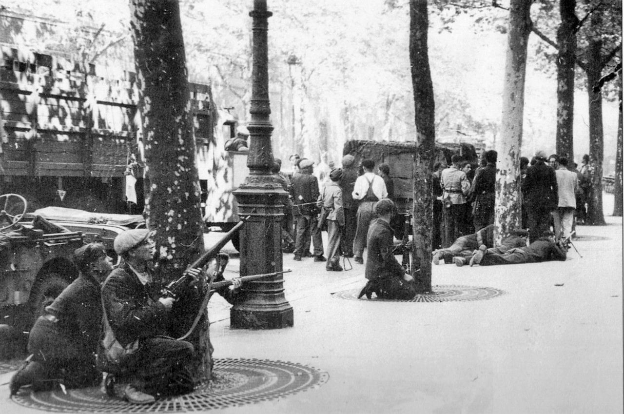 Бойцы сопротивления укрываются от огня немецких снайперов на одном из парижских бульваров, 24 августа 1944 г.