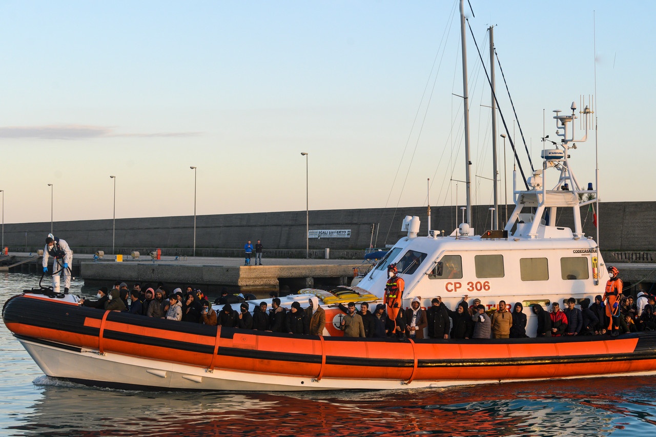 Итальянский патрульный катер с очередной партией мигрантов из стран Ближнего и Среднего Востока прибывает в порт.