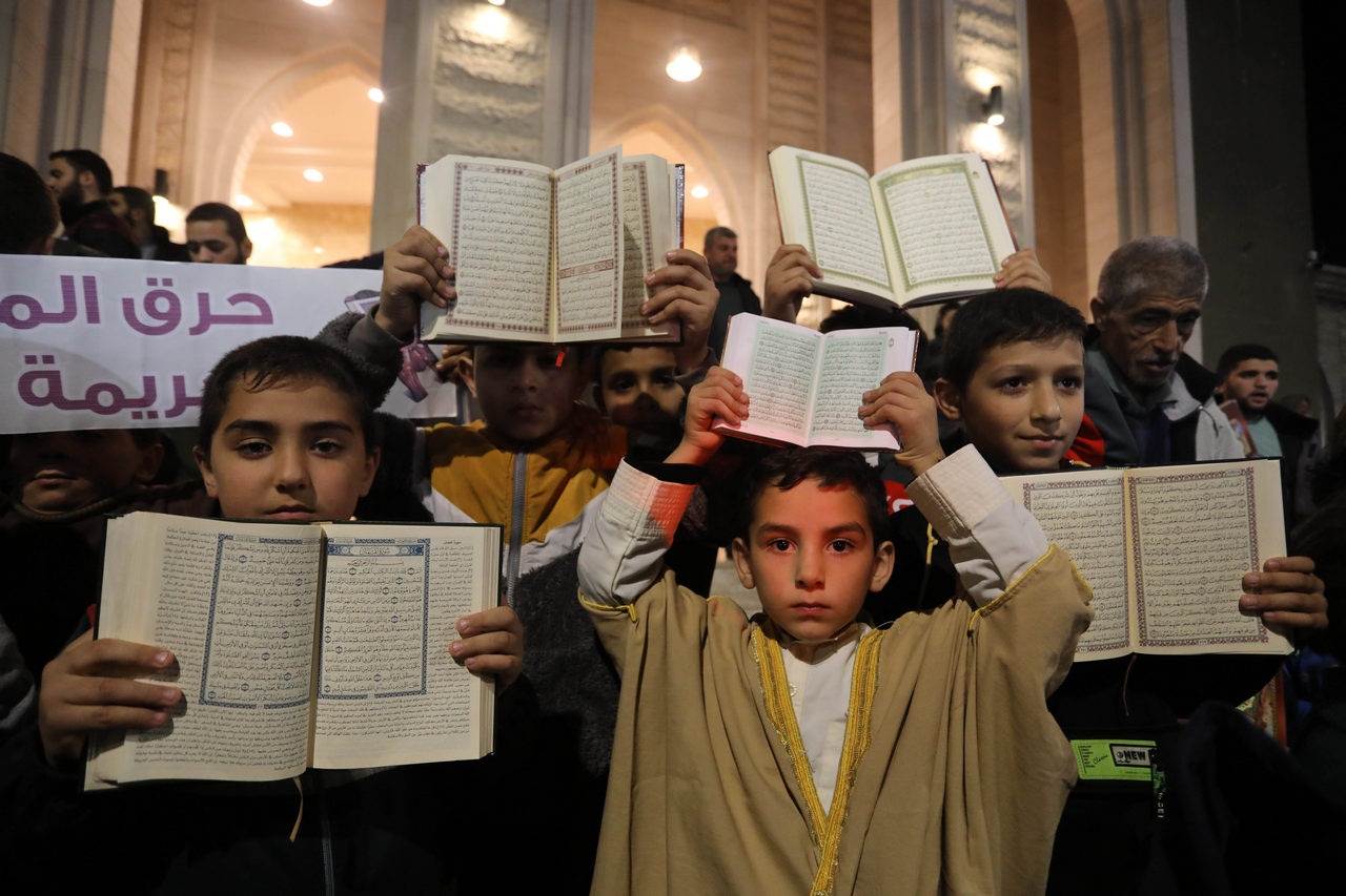 Палестинцы принимают участие в акции против сожжения священной для мусульман книги Коран.