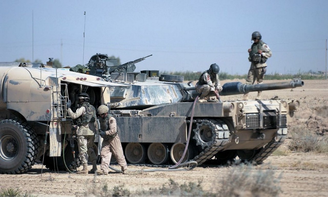 Солдаты 1-й пехотной дивизии США заправляют танк M1A1 Abrams на блокпосту, Ирак, 3 октября 2004 г.