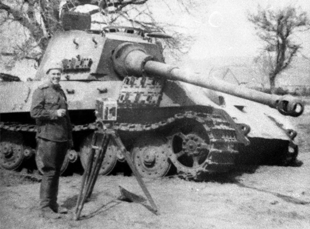 Оператор киногруппы 2-го Украинского фронта Николай Львович Прозоровский у подбитого немецкого тяжёлого танка Pz.Kpfw. VI Tiger II.