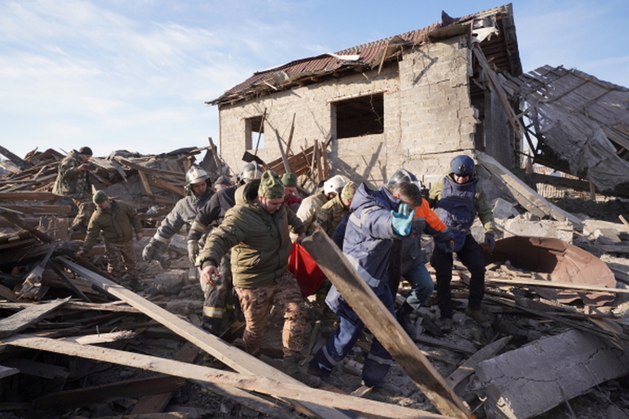 Сотрудники МЧС РФ выносят женщину, получившую ранения в результате попадания ракеты HIMARS в жилой дом в Донецке, 11 февраля 2023 г.