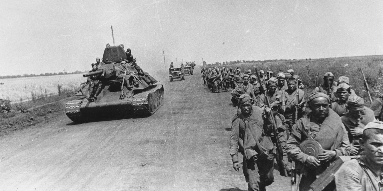 Танк Т-34 и колонна советских солдат на марше под Белгородом, август 1943 г.