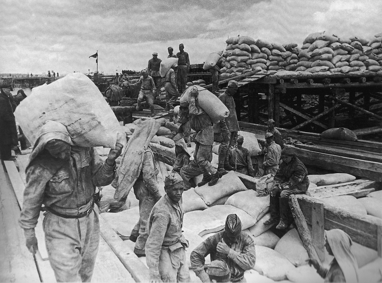 Солдаты разгружают баржу с мукой в ладожском порту Осиновец.