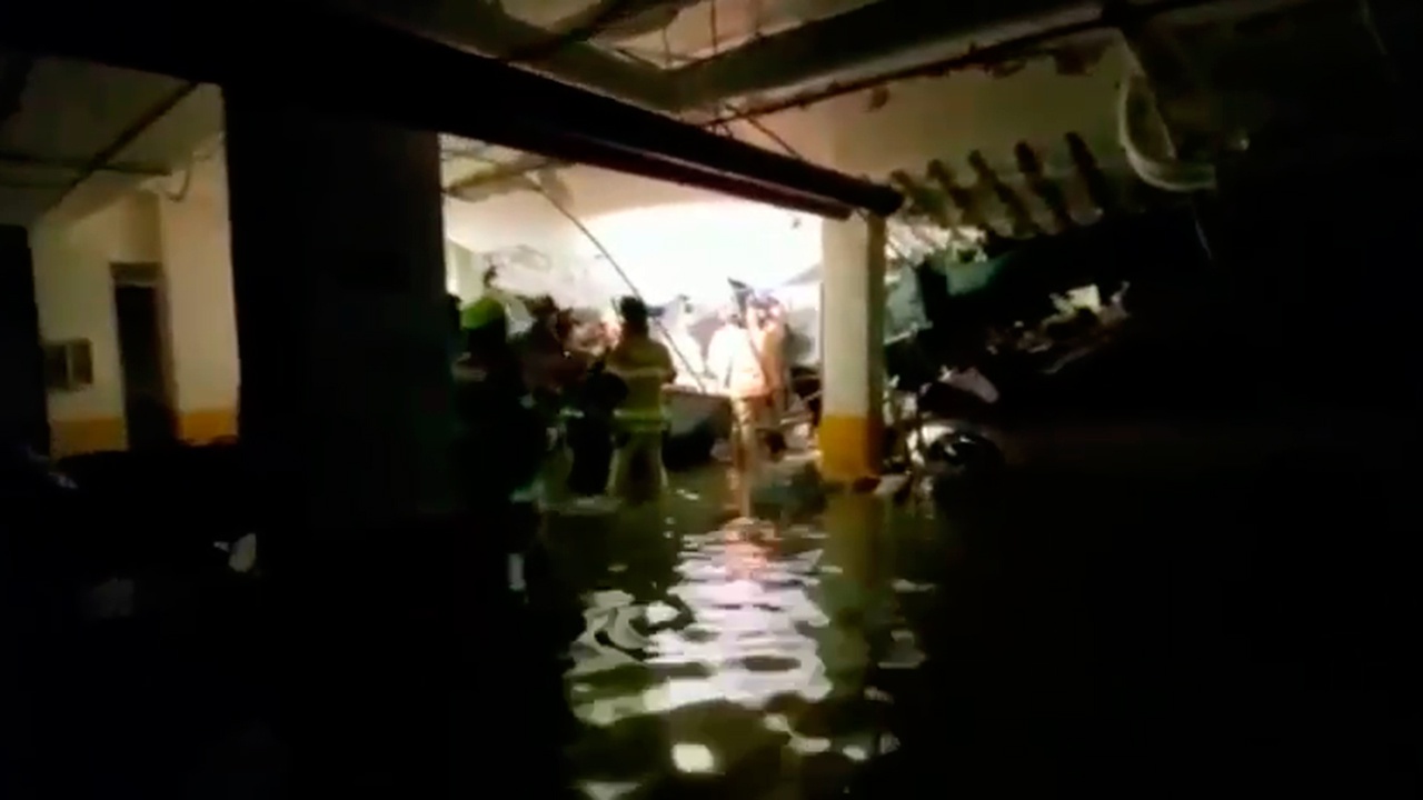 Пожарные работают в затопленном паркинге рухнувшего многоэтажного дома в штате Флорида в США